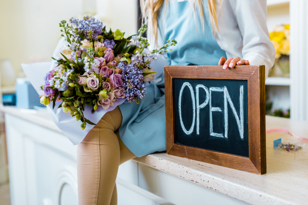női virág üzlet tulajdonosa gazdaság Palatábla a "Megnyitás" betűk és színes csokor vágott látképe - Fotó, kép