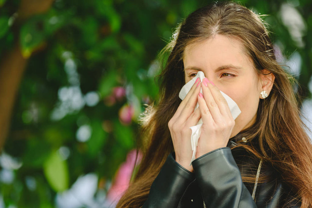Giovane donna malata millenaria starnuto tenendo fazzoletto di tessuto e soffiando asciugandosi il naso che cola
. - Foto, immagini
