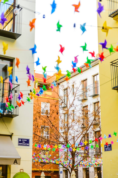 Decoration in the colorful square of the market of the Tapineria, center of the city of Valencia, where the tourists stop to rest and taste the typical Mediterranean meals, seen from below. - Photo, Image
