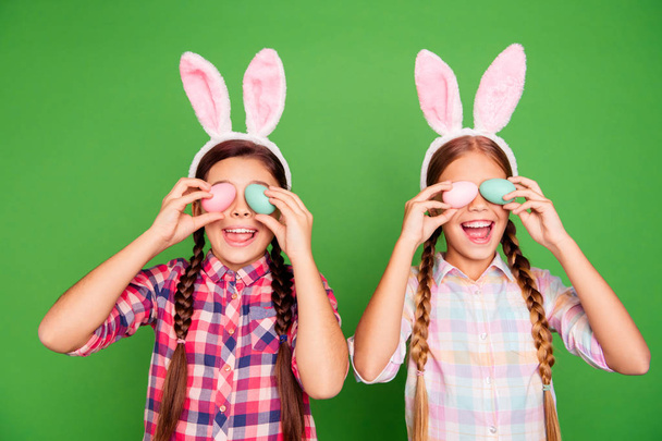 Closeup photo of two cute sweet lovely with open mouth long haired in checkered casual shirt outfit holding colorful eggs in hands isolated bright vibrant background - Foto, immagini