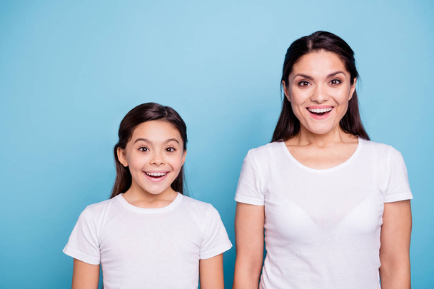Close up photo pretty two people brown haired mum small little daughter eyes mouth opened facial expression delighted sale discount wearing white t-shirts isolated bright blue background - Fotoğraf, Görsel