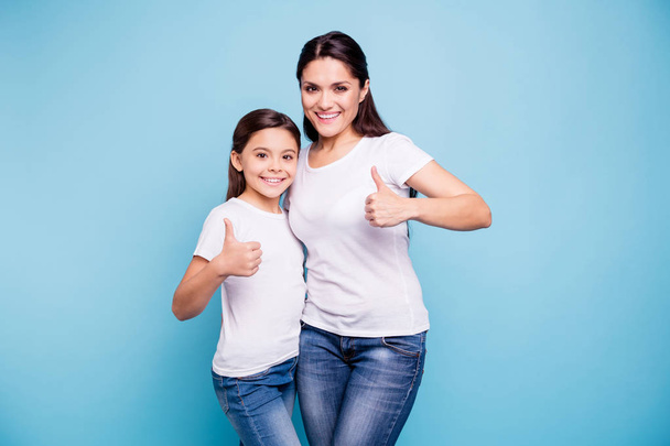 Close up photo beautiful two people brown haired mom little daughter show thumbs in air recommending hugging best friends look similar wearing white t-shirts isolated bright blue background - Fotoğraf, Görsel