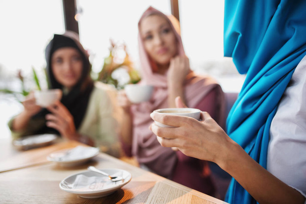 Los musulmanes se divierten en una cafetería
 - Foto, Imagen