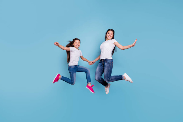 Full length body size view of two nice cute free lovely attractive cheerful cheery slim sporty people in white t-shirt holding hands having fun isolated over blue pastel background - Фото, изображение
