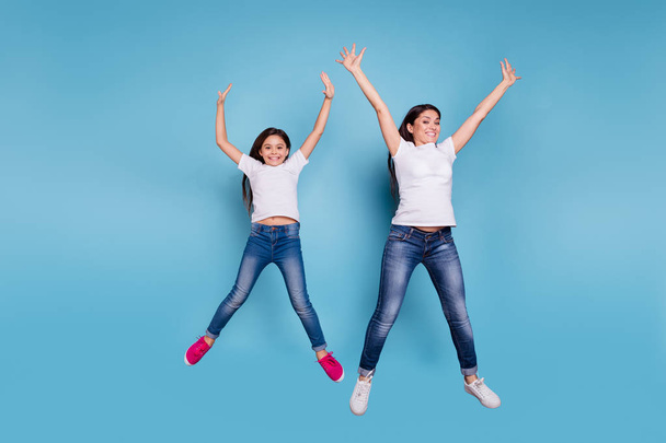Full length body size view of two nice lovely attractive charming cheerful funny slim people in white t-shirt jeans denim raising hands up party isolated over blue pastel background - Valokuva, kuva