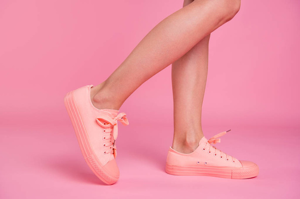 Cropped image view photo of nice attractive fit thin slim clean clear shaven healthy legs cozy comfort footgear walking sporty lifestyle isolated over pink pastel background - Fotografie, Obrázek