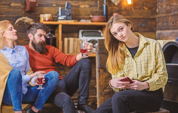 Girl with blond hair and big eyes surfing the net on her gadget. Teenager spending time on her own, growing up concept. Parents talking and enjoying drink while daughter chats with friends over phone - Foto, Imagem