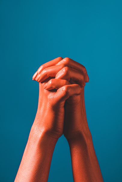 cropped view of woman gesturing with coral colored hands on blue background, color of 2019 concept - 写真・画像