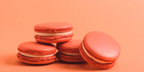 tasty coral macarons on purple background, color of 2019 concept - Фото, зображення