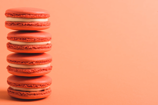 stack of coral macarons on coral background with copy space, color of 2019 concept - Φωτογραφία, εικόνα