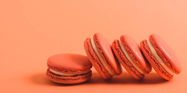 tasty coral macarons on coral background, color of 2019 concept - Φωτογραφία, εικόνα