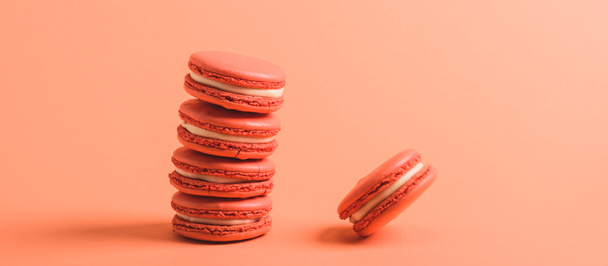 delicious macarons on coral background, color of 2019 concept - Zdjęcie, obraz
