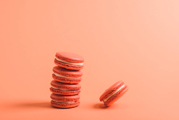 tasty coral macarons on coral background, color of 2019 concept - Zdjęcie, obraz
