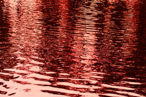 abstrakter Hintergrund von gewelltem Wasser rot getönt - Foto, Bild