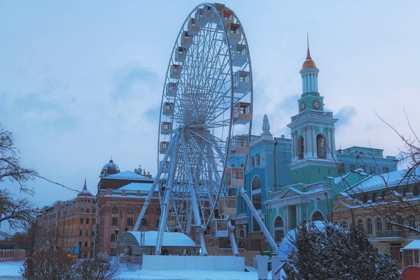 キエフ市の風光明媚な冬の風景です。コントラクトヴァ広場 (広場の契約) の観覧車の眺め。Podil はキエフの最も古い地区のひとつです。ウクライナ.  - 写真・画像