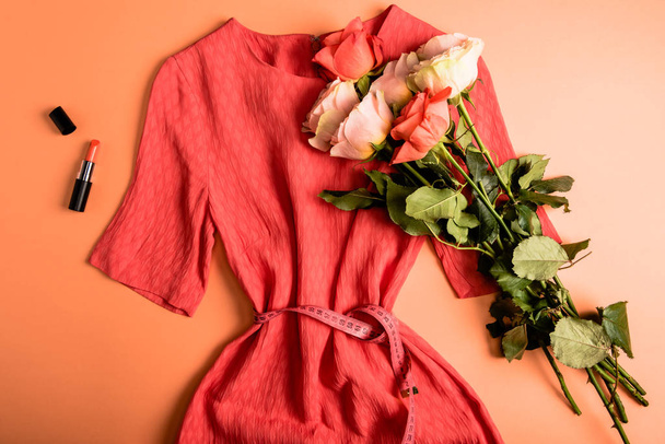 Coral sukienka, bukiet róż i koral szminka na koral tło, kolor koncepcja 2019 roku - Zdjęcie, obraz