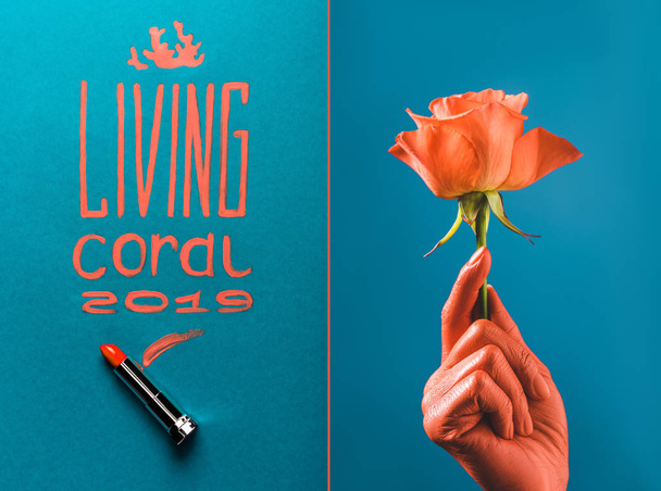 kleur van het jaar 2019 handgeschreven belettering met koraal lippenstift, en gedeeltelijke weergave van koraal gekleurde vrouwelijke hand met coral rose op blauwe verdeelde achtergrond - Foto, afbeelding