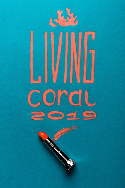 color of year 2019 handwritten lettering with coral lipstick on blue background - Photo, Image