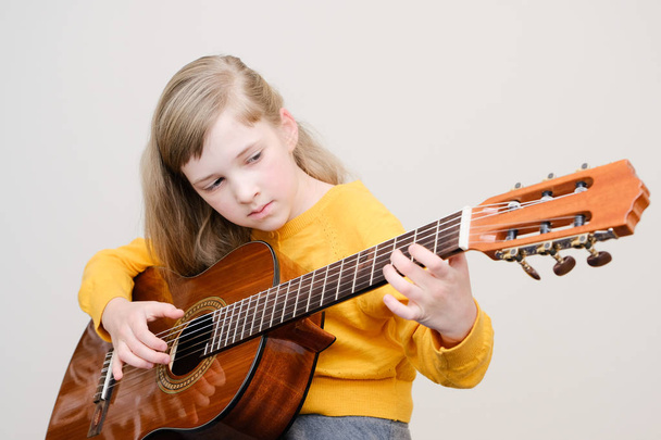 Szép kis lány játszik akusztikus gitár - Fotó, kép