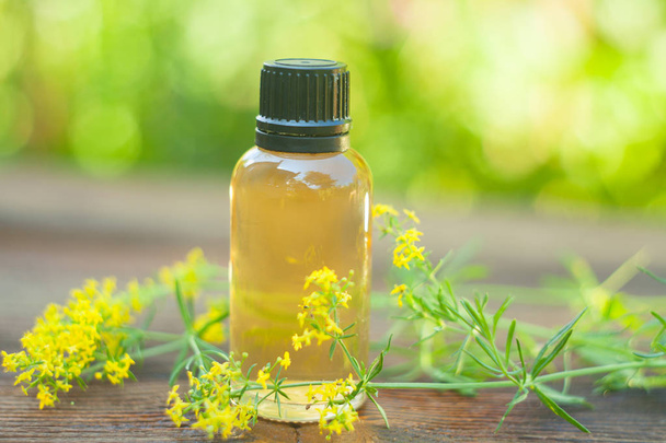 yellow bedstraw essential oil in a beautiful bottle on the table - Photo, Image