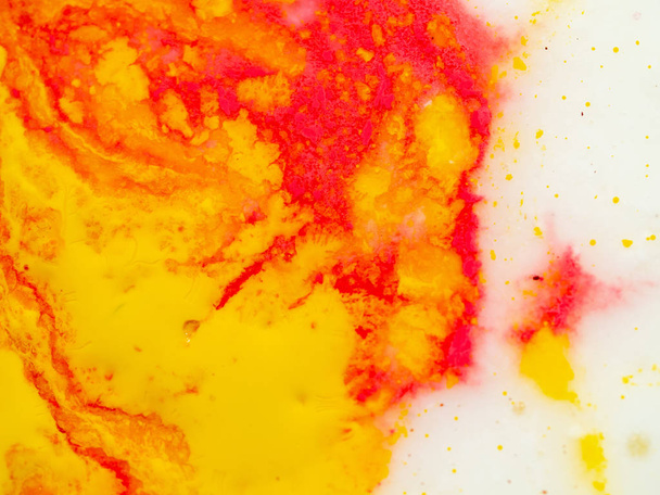 Colourful abstract background. Close up shot. Blurred background. Abstract pattern of yellow and red paint. Paint splashes on white blank. Abstract swirl of colors. Macro shot. - Foto, Imagem