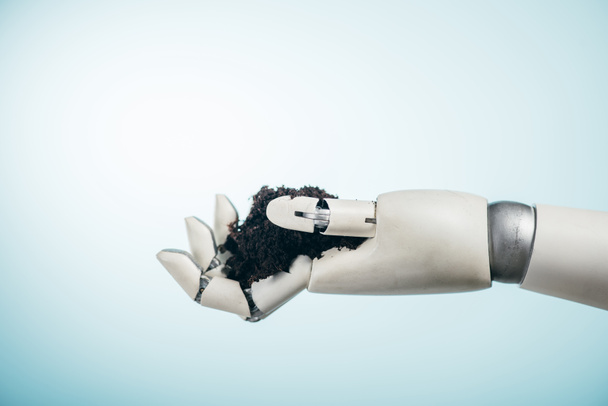 robotic hand with black ground on bicolor background, earth day concept - Photo, Image