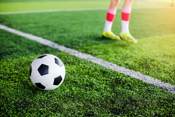 Voetbal op groen kunstgras met voetbal speler snelheid uitgevoerd aan opleiding of voetbalwedstrijd. - Foto, afbeelding