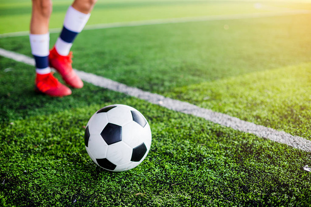 Voetbal op groen kunstgras met voetbal speler snelheid uitgevoerd aan opleiding of voetbalwedstrijd. - Foto, afbeelding