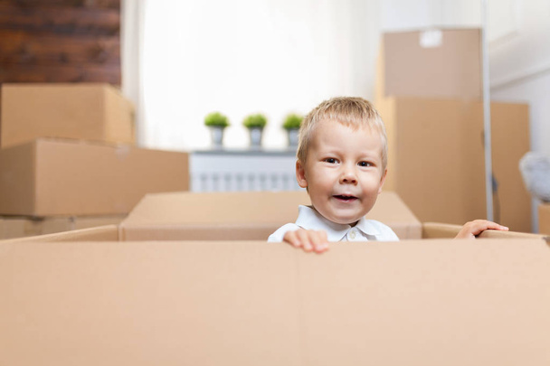 Cute toddler helping out packing boxes and moving - 写真・画像