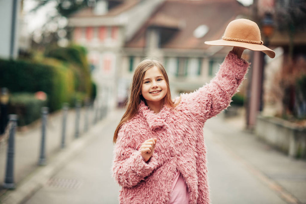 Portrait de mode en plein air de jeune fille portant un manteau rose en fausse fourrure, style de rue
  - Photo, image