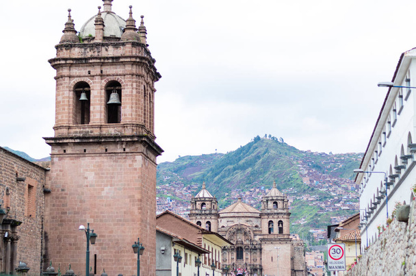 サンタ クララ教会サン ・ ペドロ教会を見ることができる都市クスコの街のバック グラウンドで - 写真・画像