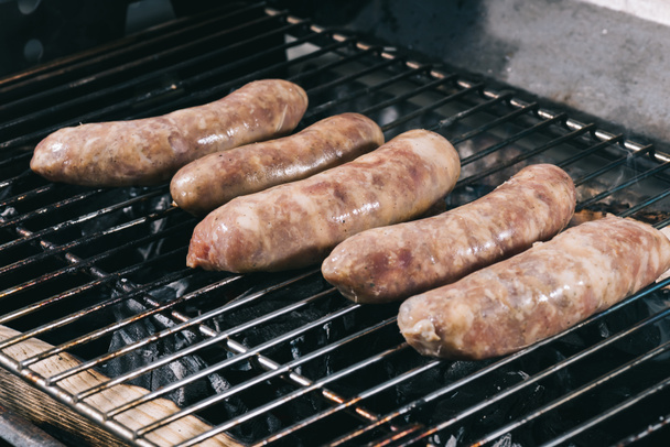 raw fresh sausages preparing on barbecue grill grate - Photo, Image