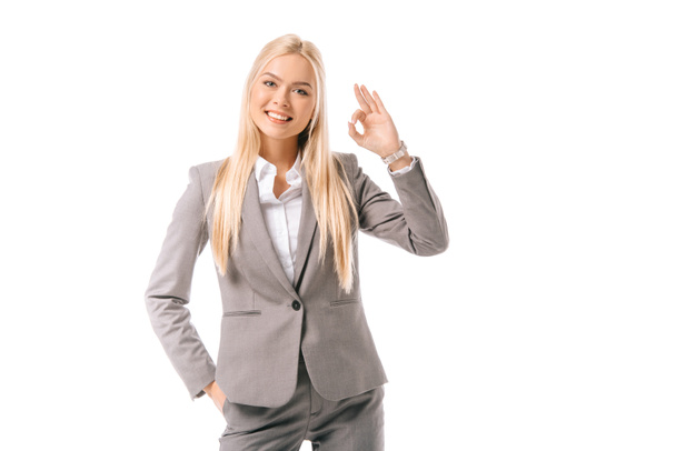 beautiful smiling businesswoman in suit showing ok sign isolated on white - Foto, Bild
