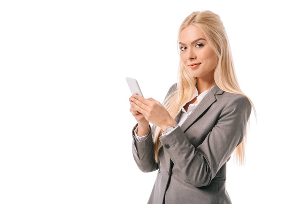 attractive blonde businesswoman using smartphone isolated on white - Foto, afbeelding