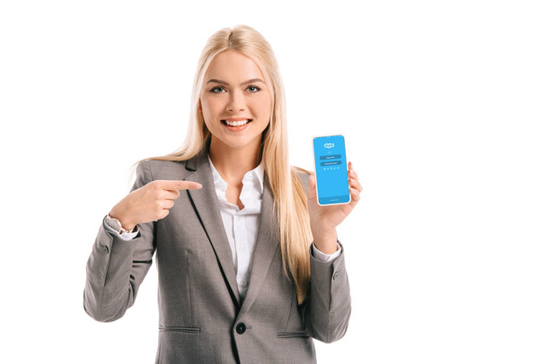 smiling businesswoman pointing at smartphone with skype app, isolated on white - Zdjęcie, obraz