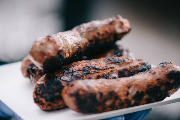 selective focus of delicious meat sausages with crust on white plate  - Photo, Image