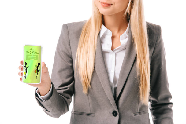 обрезанный вид деловой женщины, показывающей смартфон с лучшим приложением для покупок, изолированный на белом
 - Фото, изображение