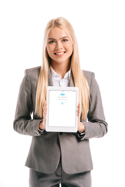 smiling blonde businesswoman showing digital tablet with skype appliance on screen, isolated on white - Foto, Bild