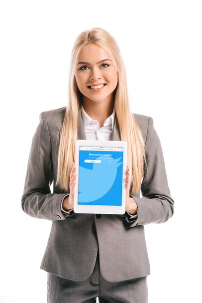 happy blonde businesswoman showing digital tablet with twitter app on screen, isolated on white - Fotó, kép