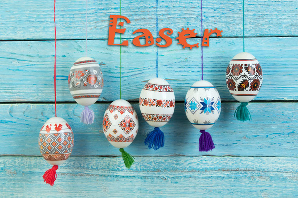 Happy Easter card. Colorful shiny easter eggs on blue wooden table background. Copy space for text - Photo, Image