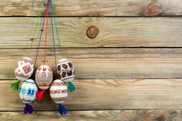 Счастливой Пасхальной открытки. Красочные блестящие пасхальные яйца на деревянном фоне стола. Копирование текста
 - Фото, изображение