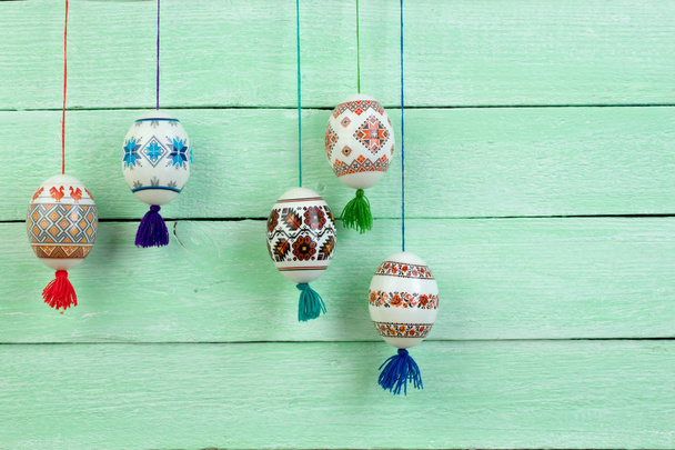 Buona Pasqua. Colorate uova di Pasqua lucide su sfondo verde tavolo di legno. Copia spazio per testo
 - Foto, immagini