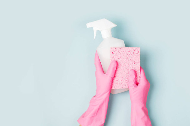 Hands in pink gloves hold detergents. Cleaning or housekeeping concept background. Copy space. Flat lay, Top view. - Photo, image