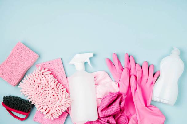 Detergents and cleaning accessories  in pink color.  Cleaning service concept. Flat lay, Top view. - 写真・画像
