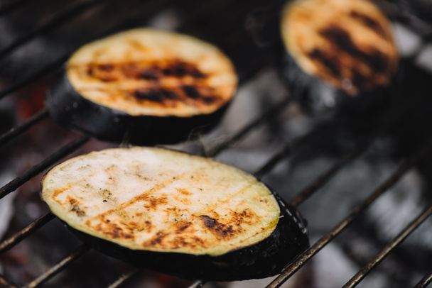 selective focus of eggplant slices grilling on barbecue grid - Photo, Image