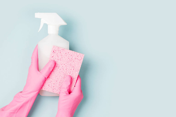 Hands in pink gloves hold detergents. Cleaning or housekeeping concept background. Copy space. Flat lay, Top view. - Photo, Image