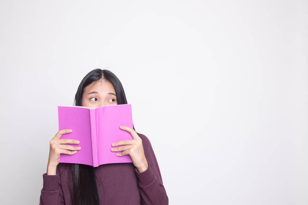 Giovane donna asiatica con una copertina del libro il suo volto su sfondo bianco
 - Foto, immagini