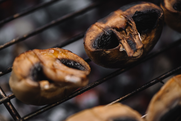 selective focus of delicious mushrooms grilling on barbecue grid - Fotoğraf, Görsel