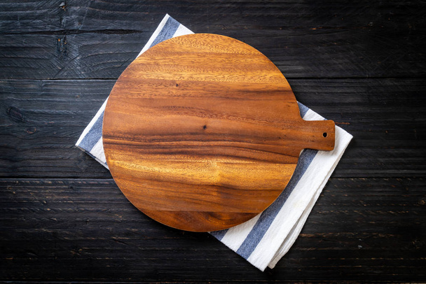 empty cutting wooden board with kitchen cloth on wood background - Fotó, kép