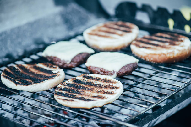 selective focus of delicious fresh burgers ingredients with crust grilling on barbecue grid - Fotografie, Obrázek